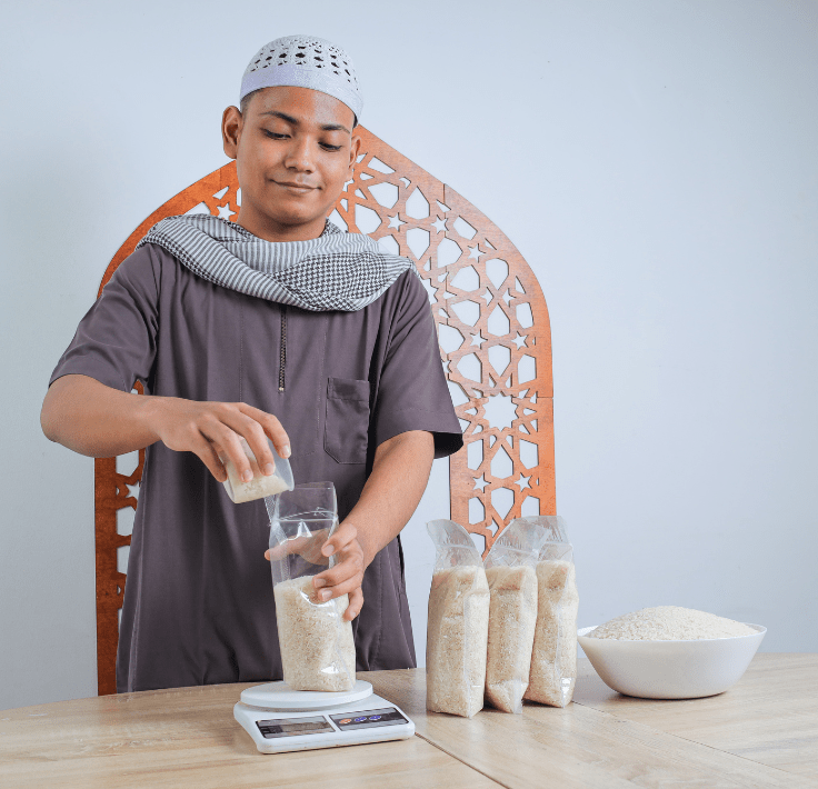 Muslim man weighing and calculating rice to distribute as Zakat